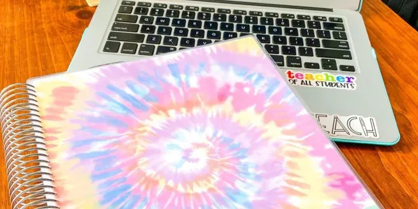 personalized teacher planner on top of desk with computer in background