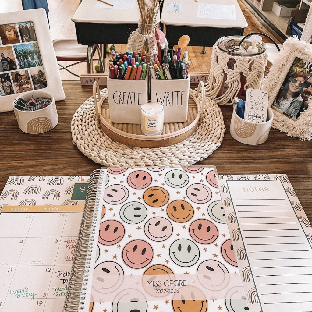 teacher with personalized teacher planner cover on desk planning in classroom